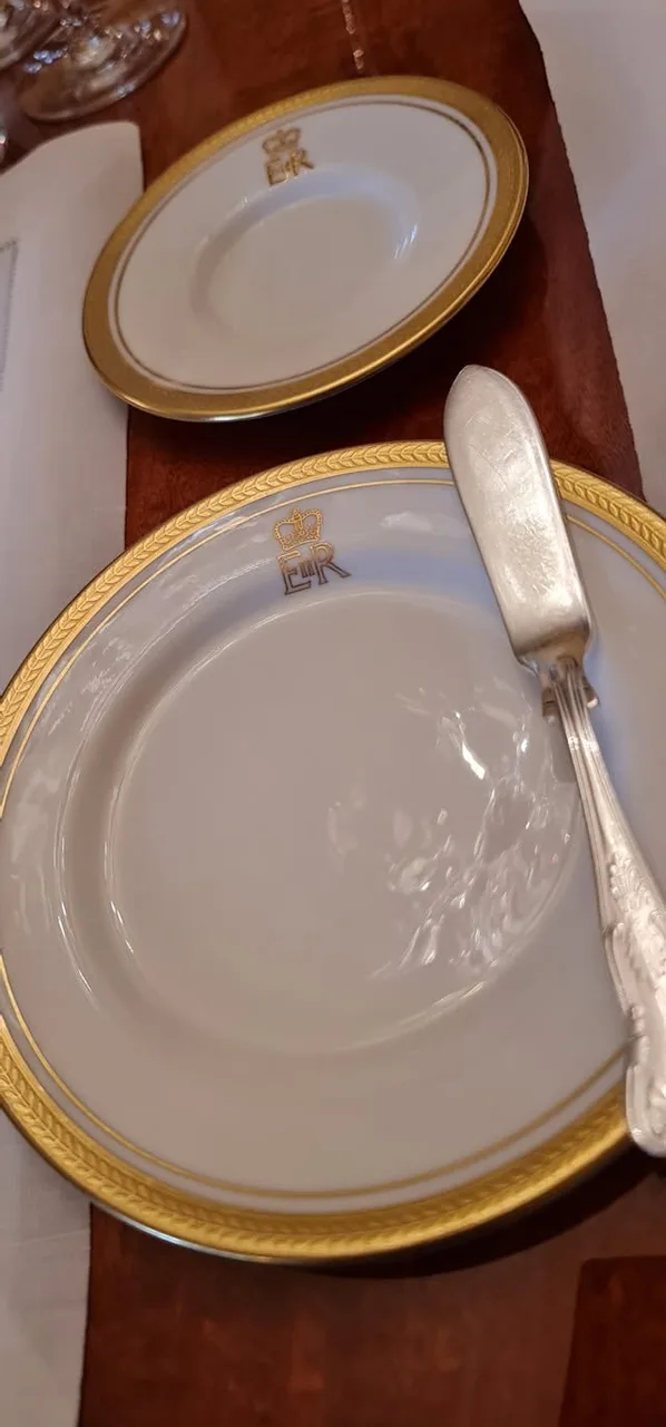 Gold-rimmed tableware bearing a crowned monogram at Government House